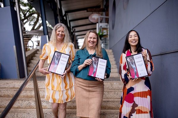 Group of 3 female finalists holding their awards