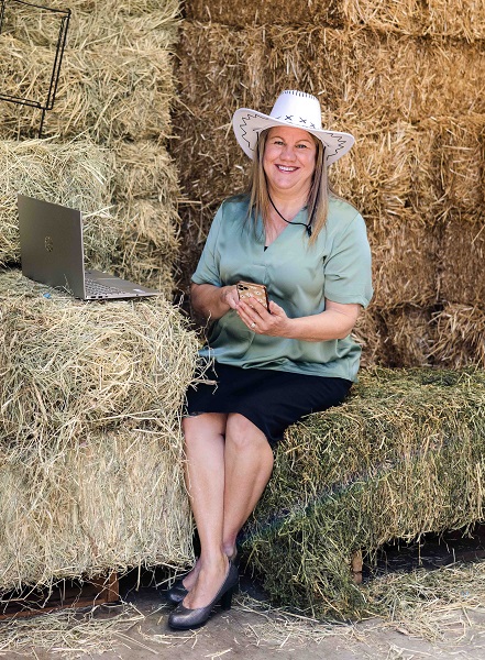 woman in white cowboy hat does a Google search on her phone