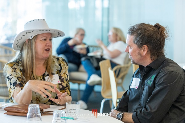 client talking to woman wearing a white cowboy hat