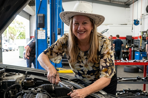 SEO professional wearing a white hat tinkering under the hood of a car